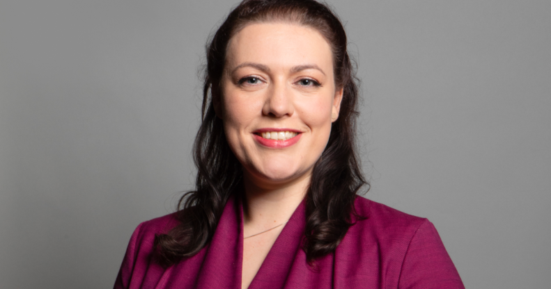 Alicia Kearns in a pink shirt and in front of a grey background