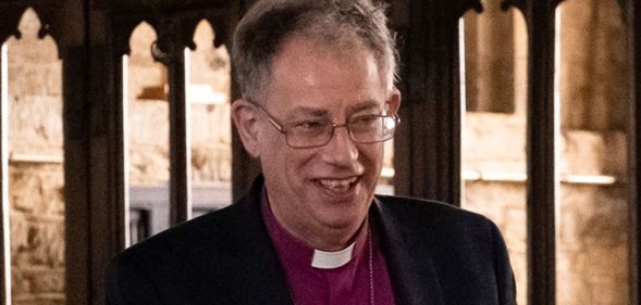 Steven Croft smiles while inside a Church of England church.