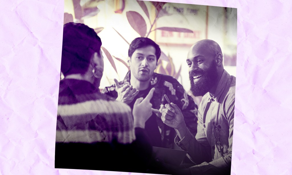 A group of coworkers are gathered around and talking