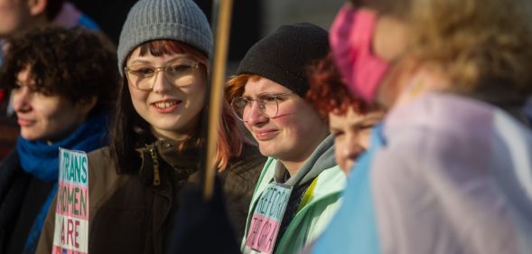 Protestors stand outside during a small protest against the UK government blocking Scotland GRA reforms.