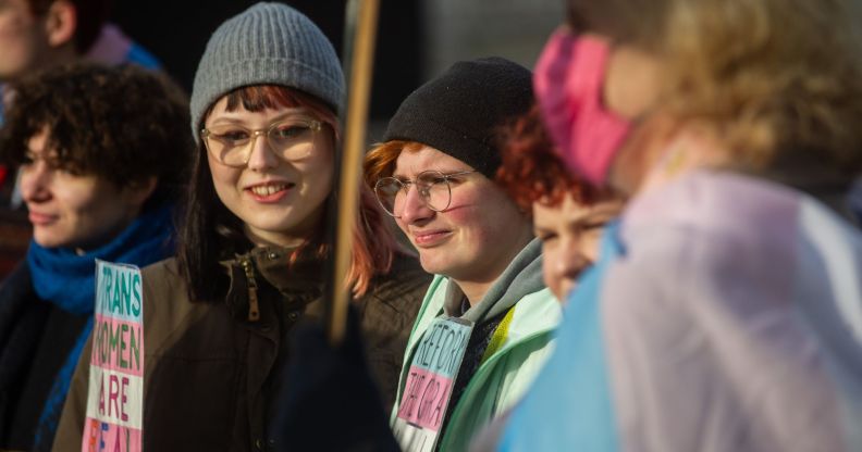 Protestors stand outside during a small protest against the UK government blocking Scotland GRA reforms.