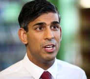 UK prime minister Rishi Sunak wears a white shirt and red tie as he speaks to someone off camera