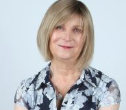 Steph Richards, founder of TransLucent, smiles at the camera while wearing a black and white floral print top