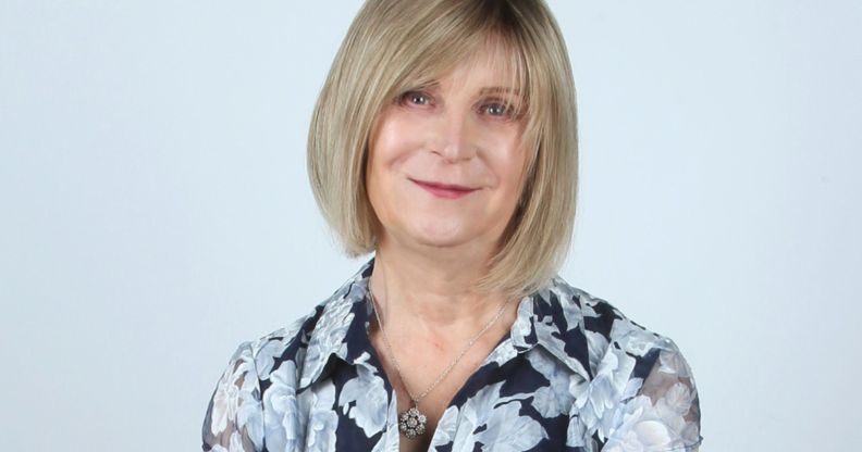 Steph Richards, founder of TransLucent, smiles at the camera while wearing a black and white floral print top