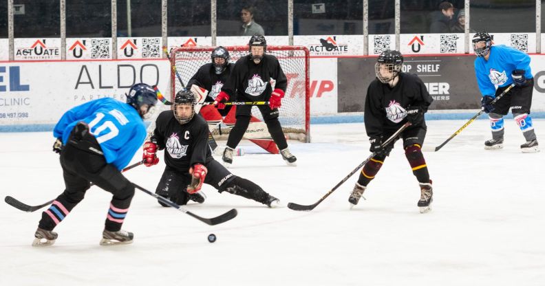 Players for Team Trans play hockey against each other on the ice