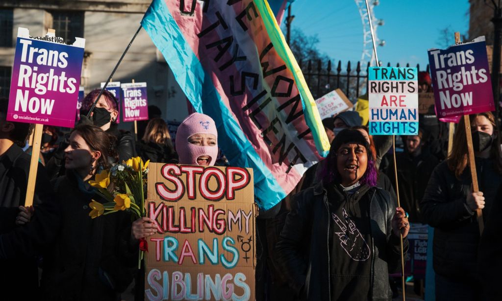 Trans rights advocates hold up signs in support of the trans community as they gather outside Downing Street after the UK government blocked Scotland's Gender Recognition Reform bill