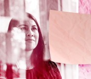 Woman looking at sticky notes at work