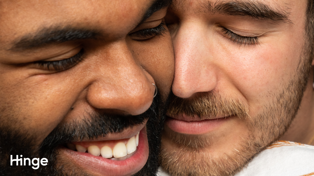 Two men smiling with their faces pressed togther