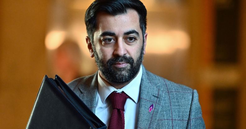 Humza Yousaf walking down a hall.