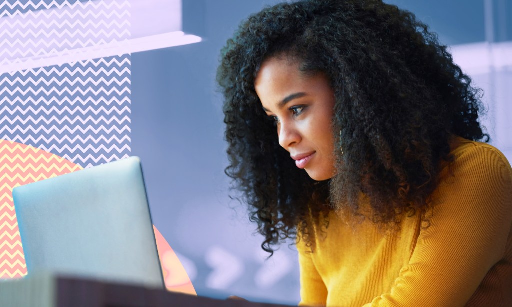 A woman is looking at her laptop.