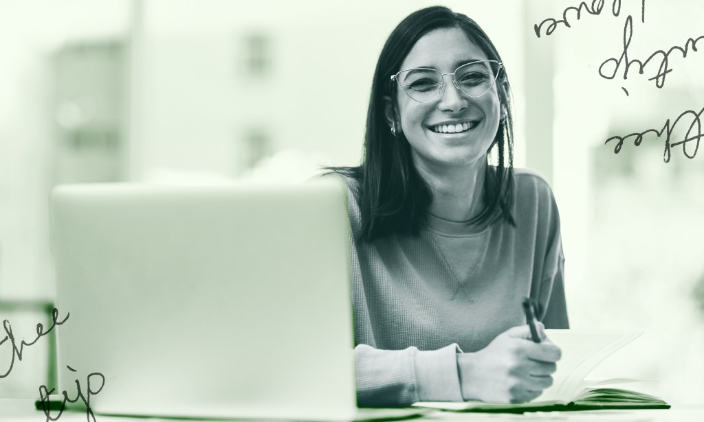 A woman is smiling and taking notes.