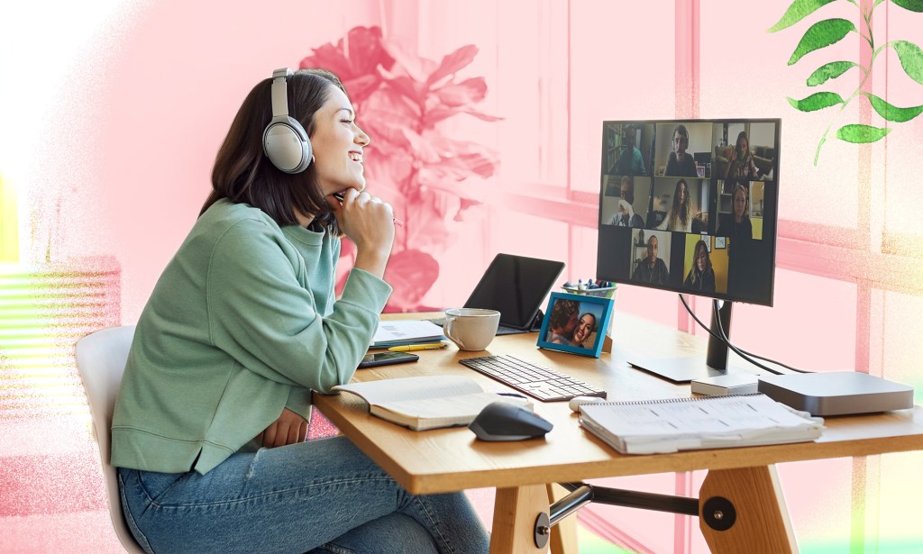 A woman is wearing headphones and is conversing with her coworkers.