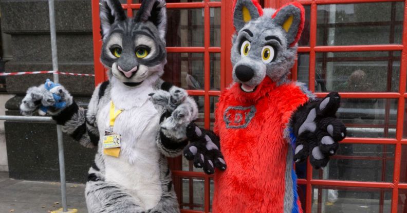 Two people, who are part of the furry community, dress in colourful fursuits as they pose outside in London for a photograph