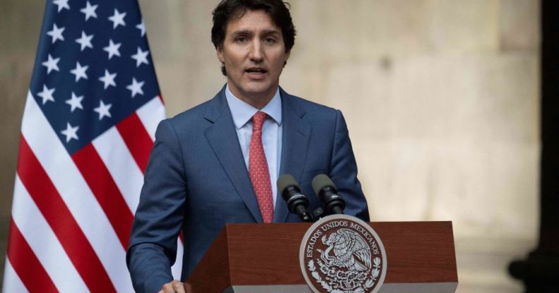 Justin Trudeau in front of a US flag