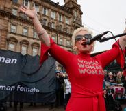 Anti-trans activist Kellie-Jay Keen, also known as Posie Parker, wears a red outfit as she speaks at an event which was met with counter-protesters