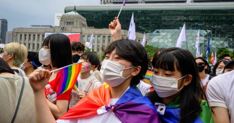 A crowd of people waving Pride flags