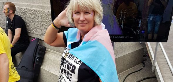 Suse Green, a trans advocate, wears a trans Pride flag as she poses for the camera