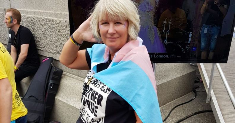 Suse Green, a trans advocate, wears a trans Pride flag as she poses for the camera