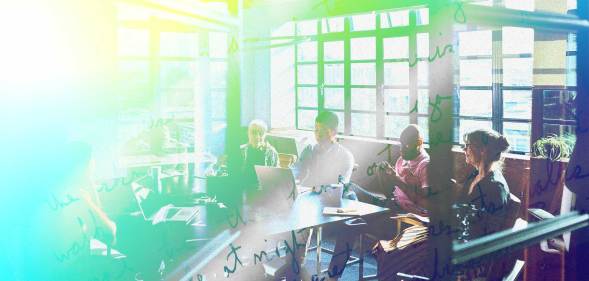 A group of colleagues are sitting in a meeting room. There is a bright green and yellow tint.