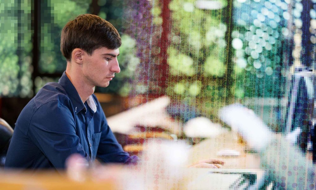 A man is looking down at a computer screen.