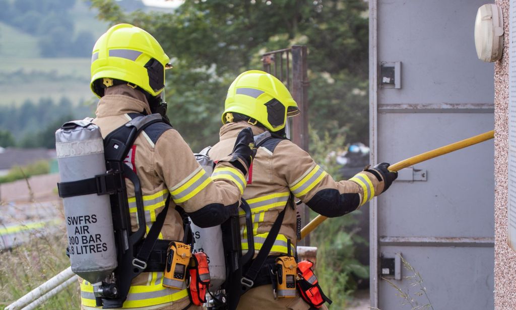 Two firefighters entering a building.