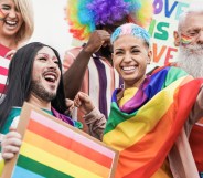 A group of LGBTQ people celebrating Pride and waving rainbow flags