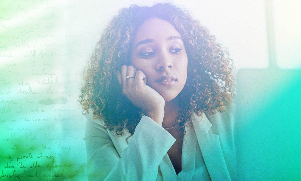 A woman looks stressed with her head resting on her hand.