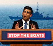 Prime minister Rishi Sunak stood behind a podium which reads 'stop the boats'