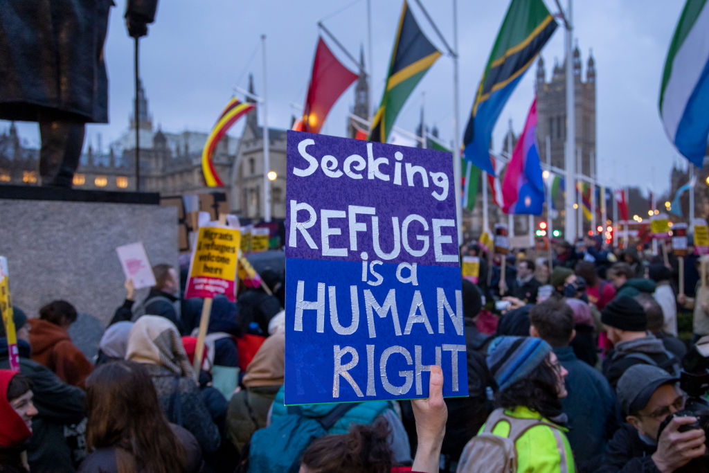 A person holds a sign which says "seeking refuge is a human right" at a pro-refugee rally in London.