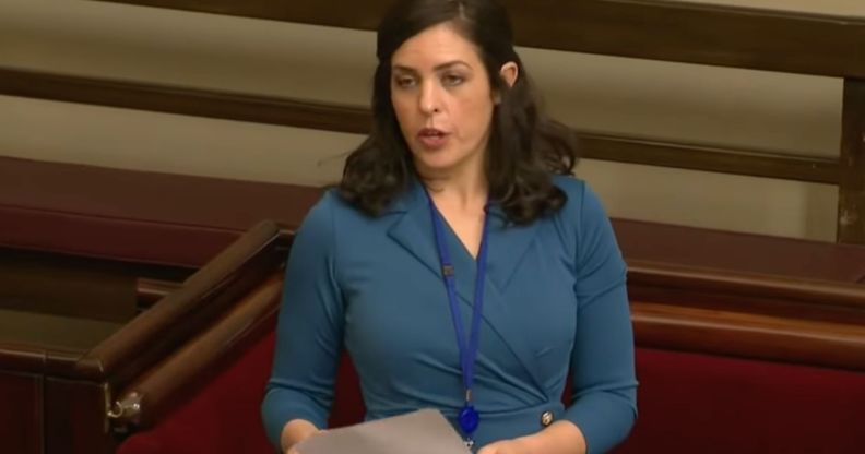 Australian MP Moira Deeming wears a blue dress as she speaks before her fellow lawmakers.