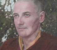 A picture of trans trailblazer Michael Dillon wearing red and yellow coloured Buddhist monk robes