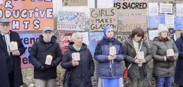 Members of an anti-abortion crowd protest outside of a hospital.