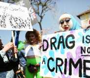 A person holds up a sign reading 'Drag is not a crime' during an LGBTQ+ protest