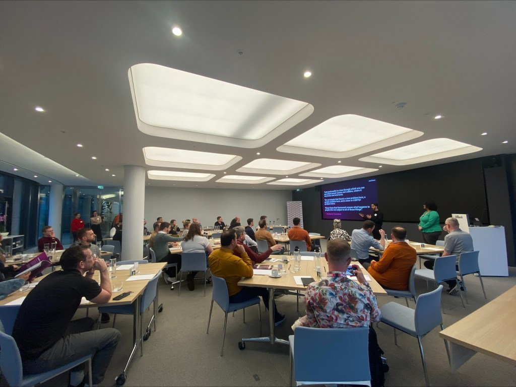 There are attendees of an event watching a presentation.