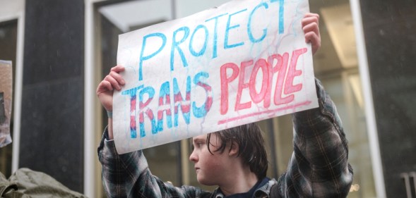 A person holds a sign reading 'Protect Trans People' as LGBTQ activists protest in Canada