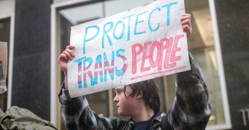 A person holds a sign reading 'Protect Trans People' as LGBTQ activists protest in Canada