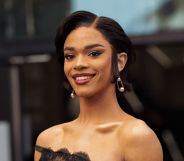 Yasmin Finney wears a black dress, pearl earrings and smiles at the camera.