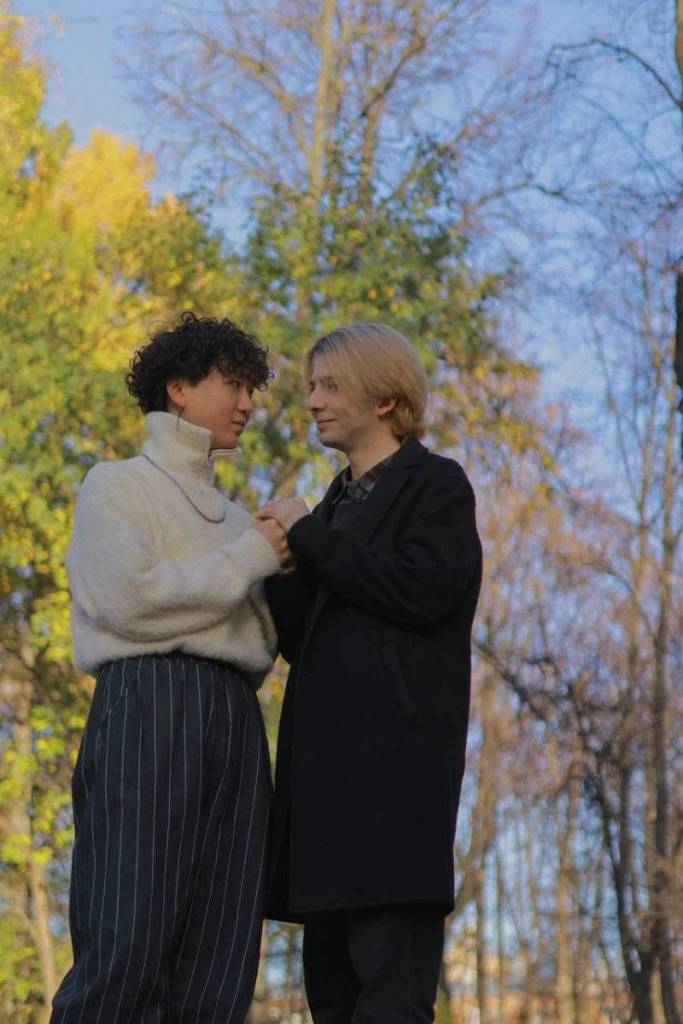 Russia based LGBTQ+ couple Haoyang Xu and Gela Gogishvil stand side-by-side as they pose outside for a picture