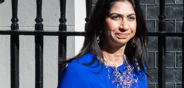 UK home secretary Suella Braverman wears a blue outfit and silver necklace as she steps outside. LGBTQ+ and human rights campaigners have criticised Braverman for her comments about asylum seekers