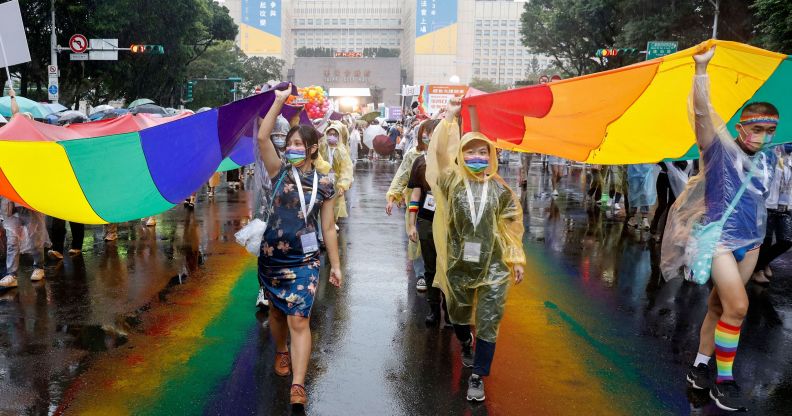 LGBT rights activists carry large rainbow banners as they march during the Gay Pride Parade in Taipei on October 29, 2022