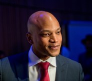 Maryland governor Wes Moore wearing a red tie and dark blue suit on a dark blue background