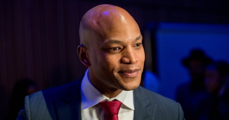 Maryland governor Wes Moore wearing a red tie and dark blue suit on a dark blue background