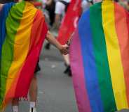 Two children wearing pride flags