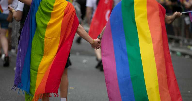 Two children wearing pride flags