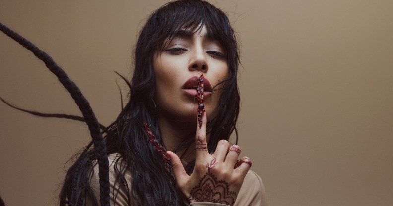 Sweden's Eurovision Song Contest 2023 winner Loreen wearing a cream top and placing a finger over her lips in a promotional photo for her Tattoo Uk and Europe Tour