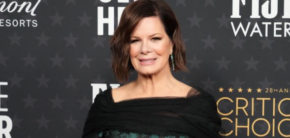 Close-up image of Marcia Gay Harden standing in front of a dark grey background