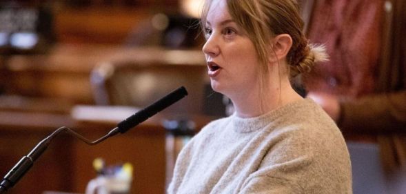 A picture of Megan Hunt speaking at her podium in the Nebraska state capitol.