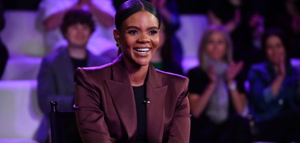 Talk-show host Candace Owens sits on a chair smiling