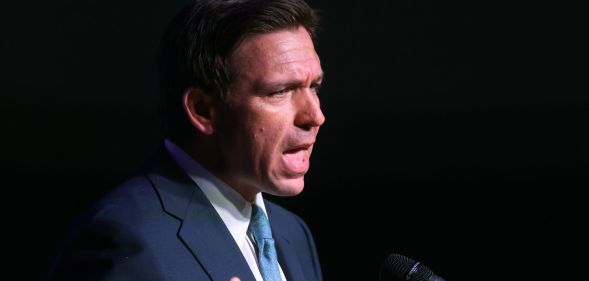 Ron DeSantis speaking infront of a pitch black backdrop.