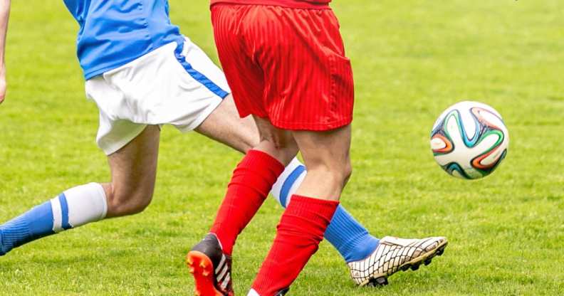 Two players lunging for a football